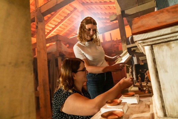 Escape Room im Wachhaus in Aktion. Zwei Spielerinnen untersuchen den römischen Götterschrein.
