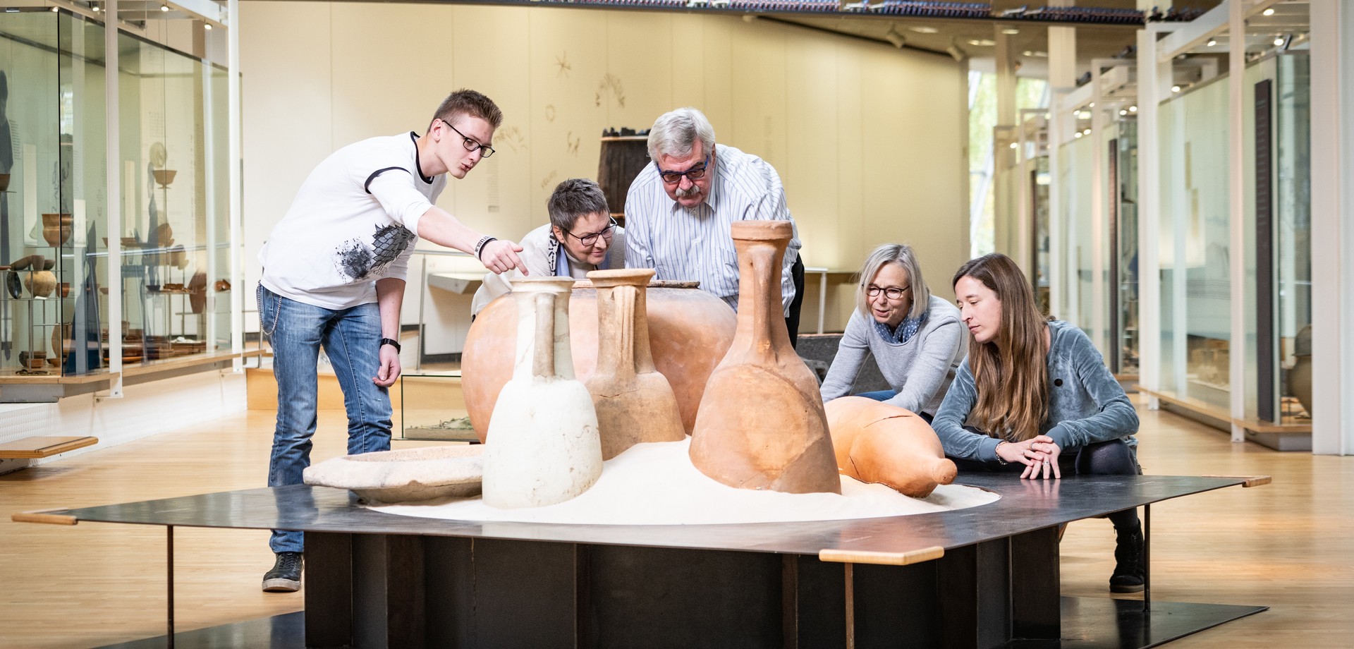 Gruppe von Erwachsenen wird durch das LWL-Römermuseum geführt