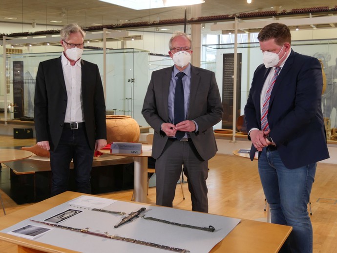 Dr. Josef Mühlenbrock, LWL-Direktor Matthias Löb und Andreas Stegemann stellen den Dolch mit Waffengurt vor. (öffnet vergrößerte Bildansicht)