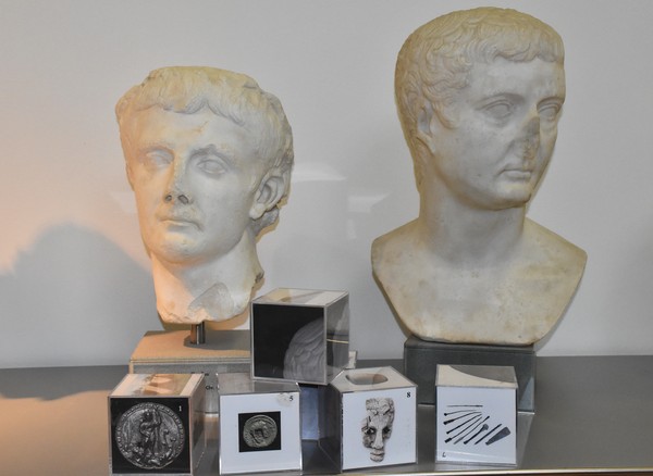 Foto: Es liegen Würfel mit Abbildungen vor zwei Büsten römischer Feldherren.