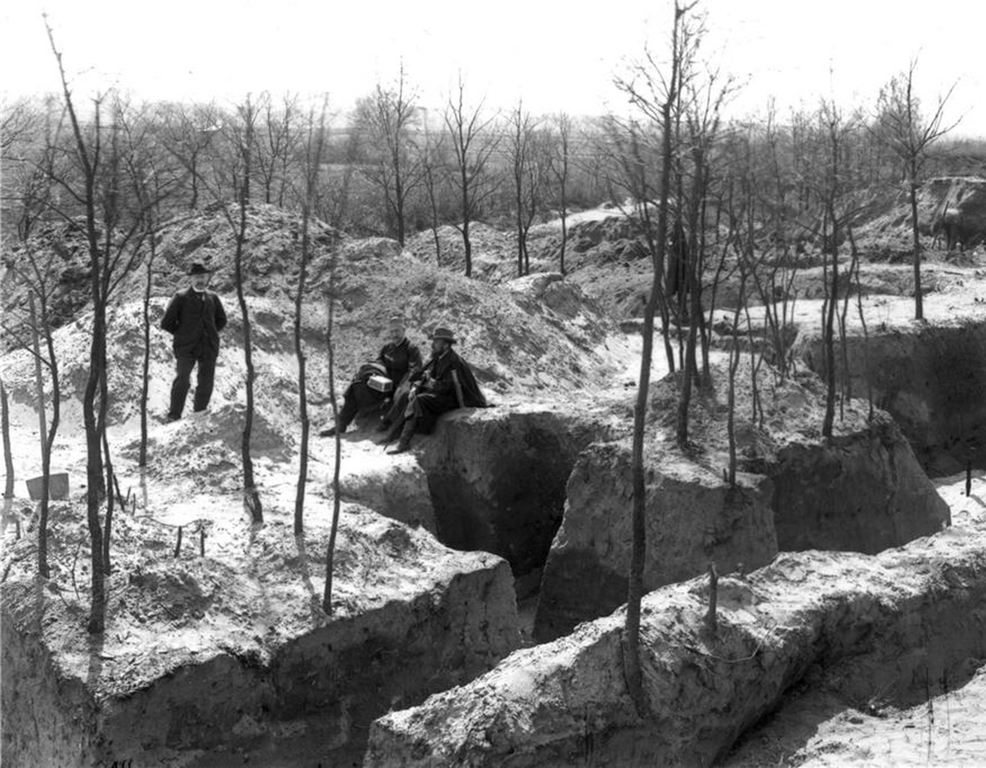 Blick auf die Ausgrabungen "Am Wiegel“: Stehend Alexander Conrads, sitzend links Alexander Conze, rechts Carl Schuchhardt,