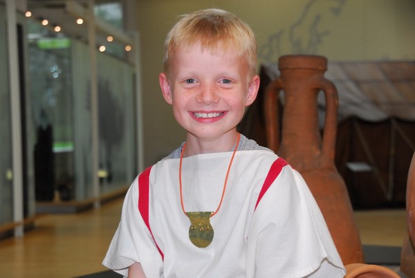 Foto: Ein Junge trägt ein selbstgebasteltes römisches Schutzamulett.