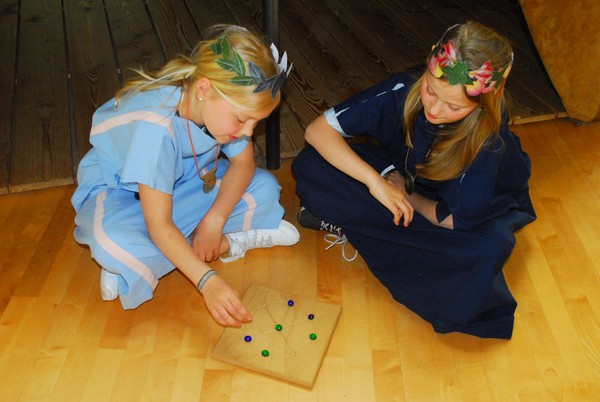 Zwei Mädchen spielen Mühle.