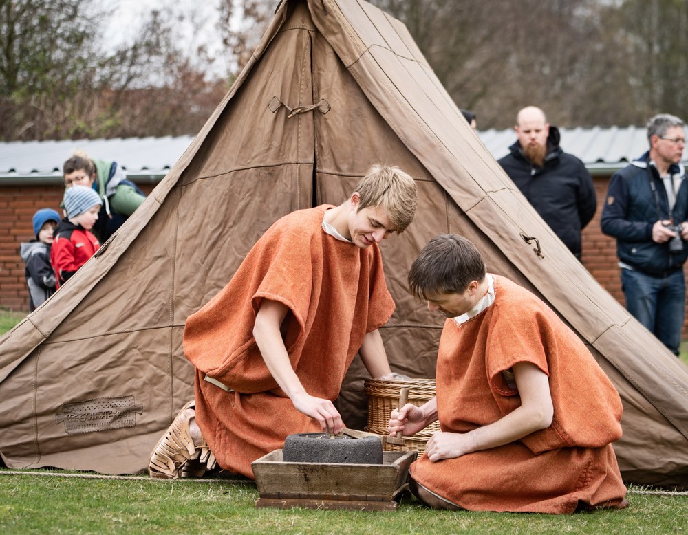 Rekruten vor einem römischen Lederzelt bereiten Essen vor