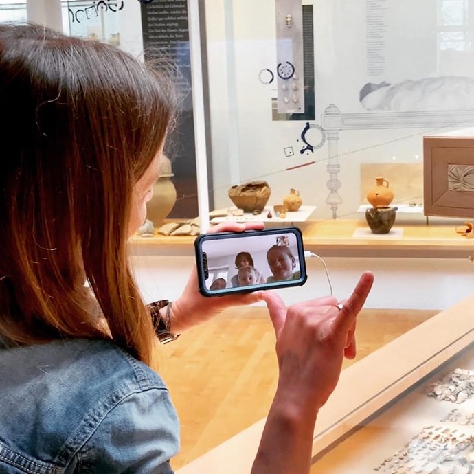 Museumspädagogin bei digitaler Führung mit Handy Museumspädagogin bei digitaler Führung mit Handy