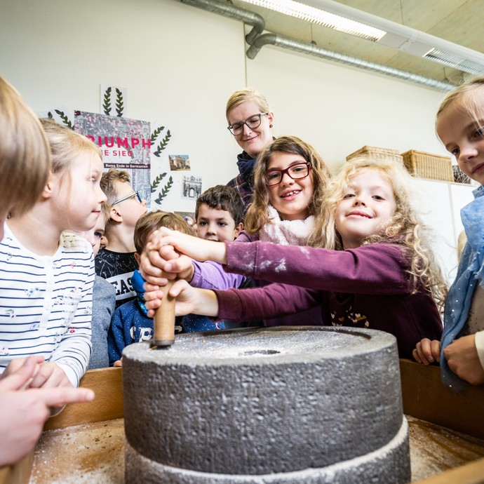 Kinder beim Mehl mahlen