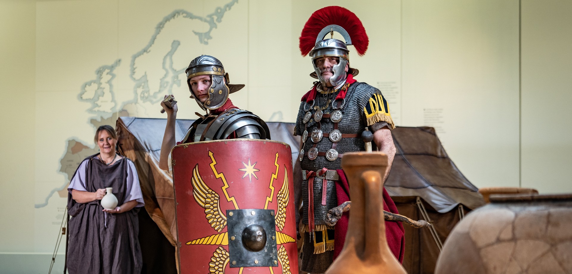 Eine Römerin mit Krug, zwei Römer in Militärausrüstung im LWL-Römermuseum