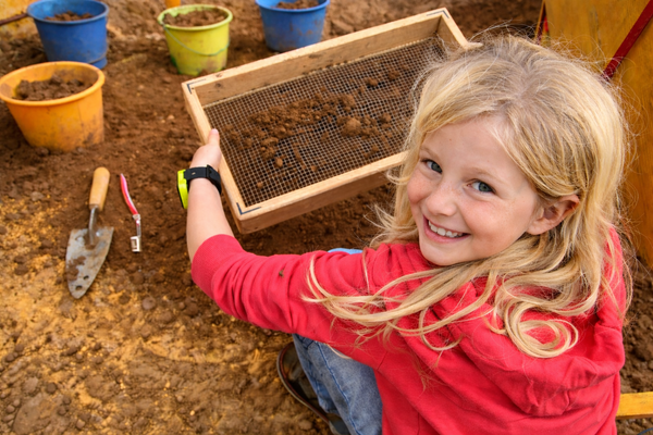 Ein Kind siebt Erde.