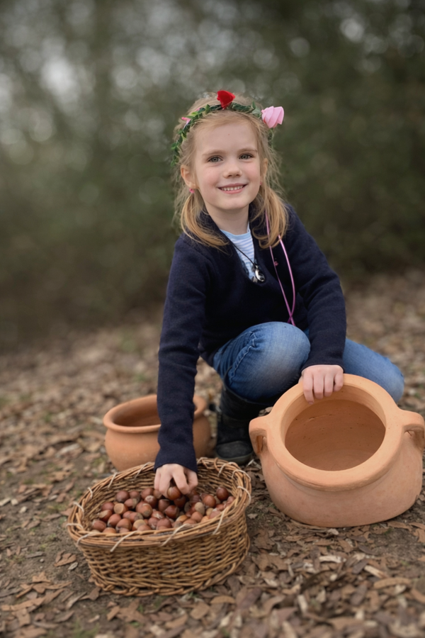 Foto: EIn Mädchen greift ihn einen Korb mit Haselnüssen.